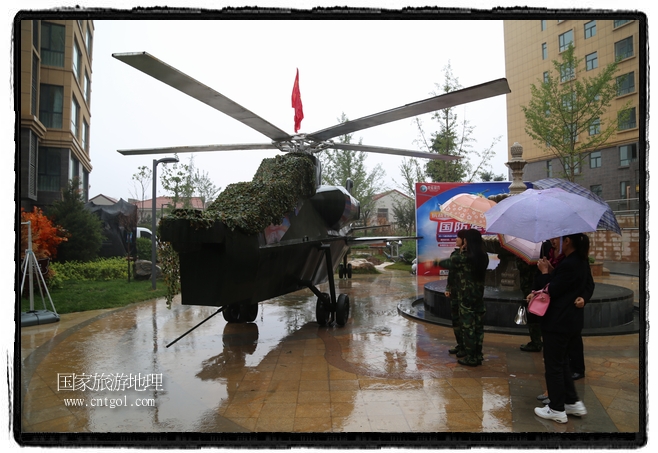 小區(qū)突然出現(xiàn)“飛機(jī)坦克”，其中殲15艦載戰(zhàn)斗機(jī)一架、99式主戰(zhàn)坦克一輛、武直-10武裝直升機(jī)一架，吸引了眾多市民雨中圍觀、合影。